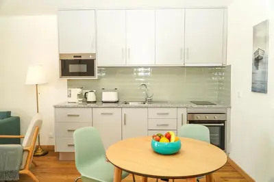 a kitchen with a table with a bowl of fruit on it at Stanchion Apartment in Albufeira