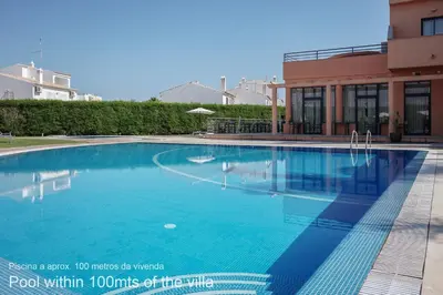 a swimming pool in front of a building at Akivillas Quarteira Relax in Quarteira