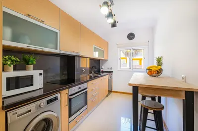 a kitchen with a washing machine and a microwave at Vale Parra Village By Cabritatur in Guia