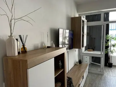 a kitchen with a counter with a tv and a window at Quarteira Beach Home Haven in Quarteira