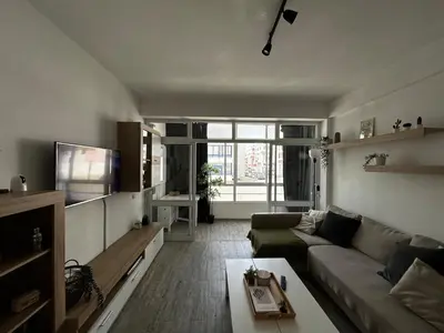 a living room with a couch and a tv at Quarteira Beach Home Haven in Quarteira