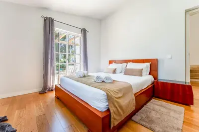 a bedroom with a large bed and a window at Casa da Paz by Algarve Holidays in Albufeira