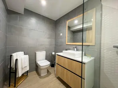 a bathroom with a toilet and a sink and a mirror at Modern Retreat 700m from the Beach - Salgados in Guia