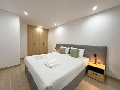 a bedroom with a large bed with white sheets at Modern Retreat 700m from the Beach - Salgados in Guia