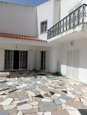 an empty courtyard of a white house with a balcony at Casa Gomez A in Albufeira