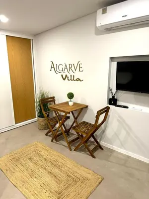 a living room with a table and chairs and a tv at Acoteias Cosy Studio in Albufeira