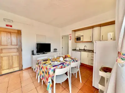 a dining room with a table and a kitchen at Albufeira Skylight 2 With Pool by Homing in Albufeira