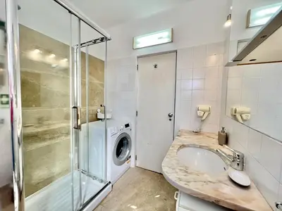 a bathroom with a sink and a washing machine at Albufeira Skylight 2 With Pool by Homing in Albufeira