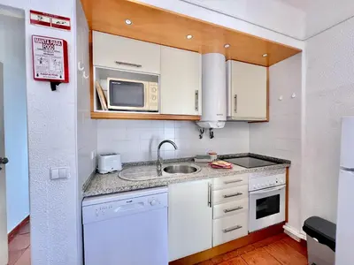 a small kitchen with a sink and a microwave at Albufeira Skylight 2 With Pool by Homing in Albufeira