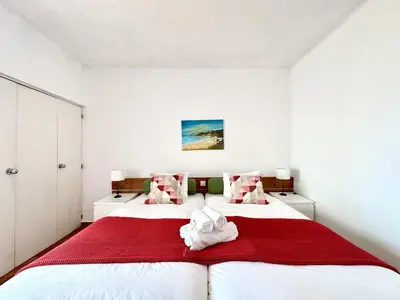 a bedroom with two beds with red and white sheets at Albufeira Skylight 2 With Pool by Homing in Albufeira