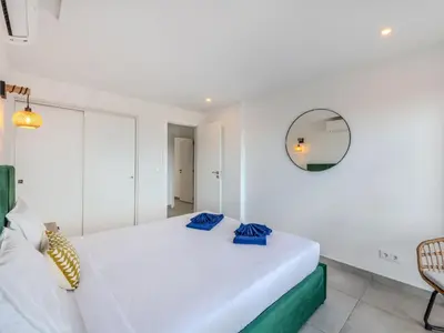a white bedroom with a bed and a mirror at Apartment Villa Magna by Interhome in Albufeira