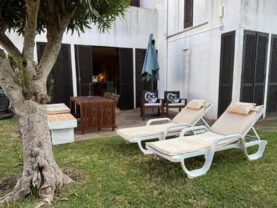two lounge chairs and a table and a tree at no22FM in Vilamoura