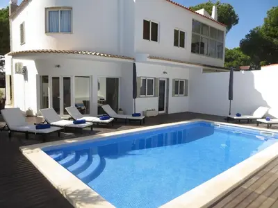 a villa with a swimming pool in front of a house at Luxury Villa with Private pool walking distance to beach and Marina in Quarteira
