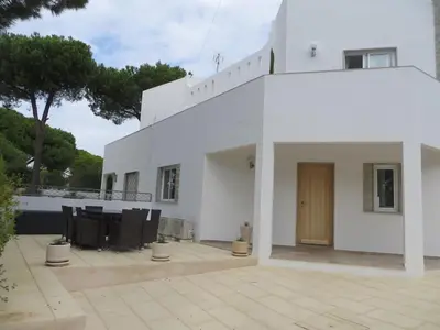 a white building with a wooden door on a patio at Luxury Villa with Private pool walking distance to beach and Marina in Quarteira