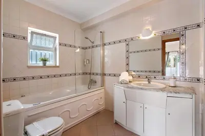 a bedroom with two beds and a wooden cabinet at Al´Corais in Albufeira