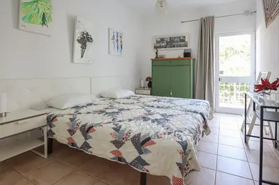 a bedroom with a bed and a desk and a window at Jardins do Castelo - Piscina e tranquilidade - BY BEDZY in Albufeira