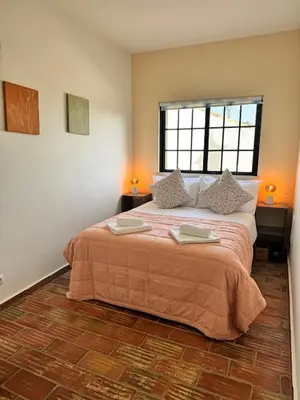 a bedroom with a large bed with a window at Casa da Parreira in Loulé