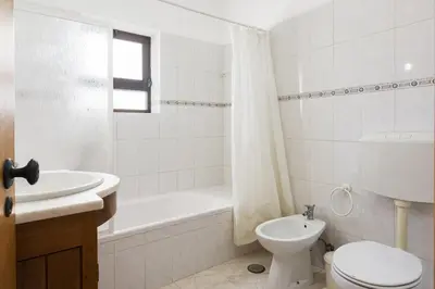 a white bathroom with a toilet and a sink at Vila de santa Eulalia II - Albufeira in Albufeira