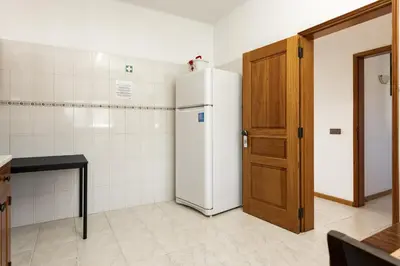 a kitchen with a white refrigerator and a wooden door at Vila de santa Eulalia II - Albufeira in Albufeira
