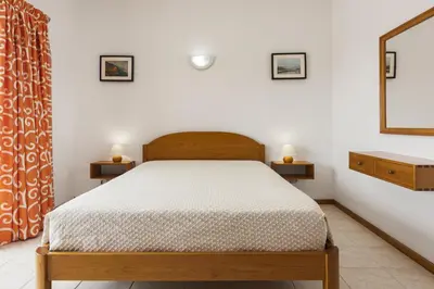 a bedroom with a bed and two side tables at Vila de santa Eulalia II - Albufeira in Albufeira