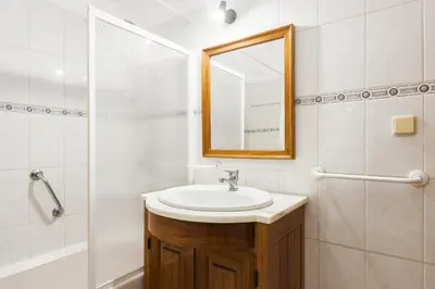 a bathroom with a sink and a mirror and a shower at Vila de Santa EulAlia III - Albufeira in Albufeira