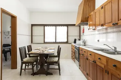 a kitchen with a table with chairs and a sink at Vila de Santa EulAlia III - Albufeira in Albufeira