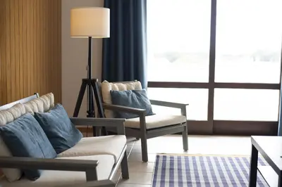 a living room with two chairs and a couch and a lamp at Vila de Santa EulAlia III - Albufeira in Albufeira