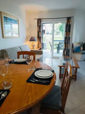 a living room with a table and a dining room at Balaia Golf Village T2 a 10 minutos da praia in Olhos de Água