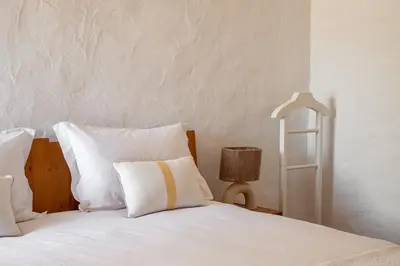 a white bed with white pillows and a lamp at True Local Village in Loulé