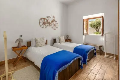 a bedroom with two beds and a bike on the wall at True Local Village in Loulé