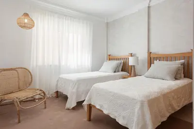 a bedroom with two beds and a chair and a window at Praia Village II - Peaceful condominium by HD in Vilamoura