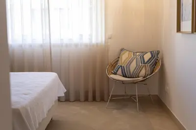a chair sitting next to a bed in a room at Praia Village II - Peaceful condominium by HD in Vilamoura