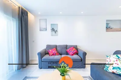 a living room with two blue couches and a kitchen at #308 Marcilia Apartamento by Home Holidays in Albufeira