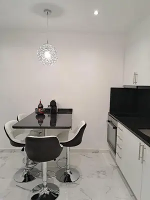a kitchen with a table and chairs in a room at Apartamento T1 a 10m da praia Quarteira in Quarteira