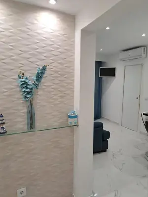 a living room with a vase of flowers on a wall at Apartamento T1 a 10m da praia Quarteira in Quarteira