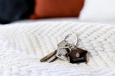 a key chain on top of a white bed at Apartamento T3 Praia da Falésia - PINE SUN PARK in Albufeira