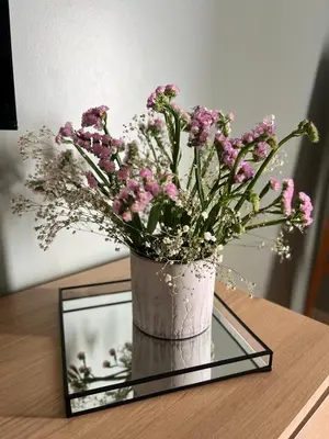 a vase of flowers sitting on a table with a mirror at casa da vila 33 in Faro