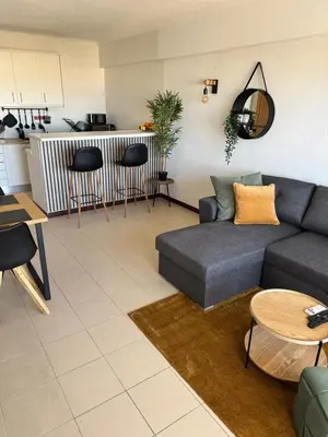 a living room with a couch and a table at Albufeira Cozy Sea View with Balcony & Resort Access in Albufeira