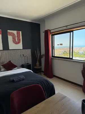 a bedroom with a bed and a large window at Albufeira Cozy Sea View with Balcony & Resort Access in Albufeira
