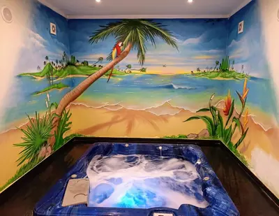 a bathroom with a painting of a palm tree and a hot tub at Villa Ocean Gale in Albufeira