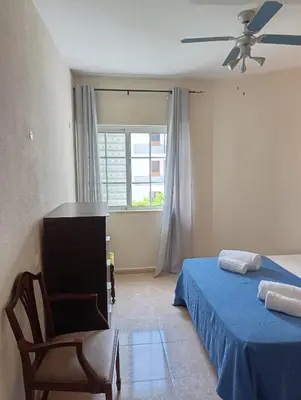 a bedroom with a bed and a chair and a window at Casa Gomez B in Albufeira