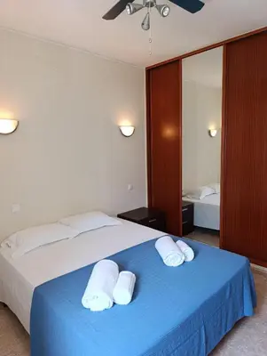 a bedroom with a blue bed with two white towels at Casa Gomez B in Albufeira