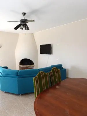 a living room with a blue couch and a fireplace at Casa Gomez B in Albufeira