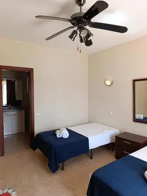 a bedroom with two beds and a ceiling fan at Casa Gomez B in Albufeira