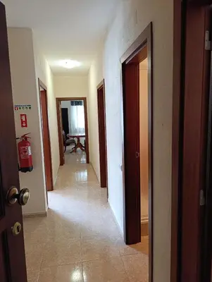 a hallway with several doors and a room with a table at Casa Gomez B in Albufeira