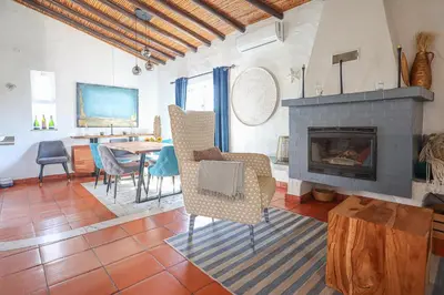 a living room with a fireplace and a table and chairs at 2 Vale de Ursa - Swimming Pool - WIFI - BY BEDZY in Guia