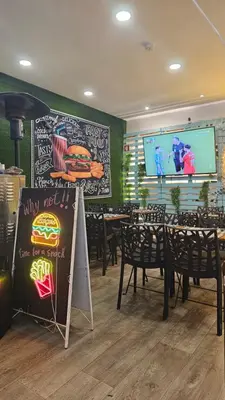 a restaurant with tables and a chalk board with a sign at Wonder Charm Guesthouse in Albufeira