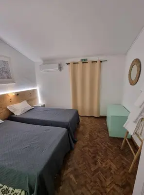a hotel room with two beds and a curtain at Wonder Charm Guesthouse in Albufeira