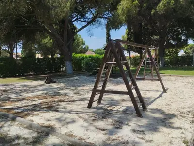 a wooden swing set in a park with trees at Açoteias Secrets in Albufeira