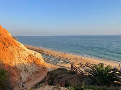 a beach with a bunch of umbrellas and the ocean at Açoteias Secrets in Albufeira